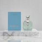 Perfume bottle and packaging with 'Arabiyat Bamboo Reflection' on a marble surface.
